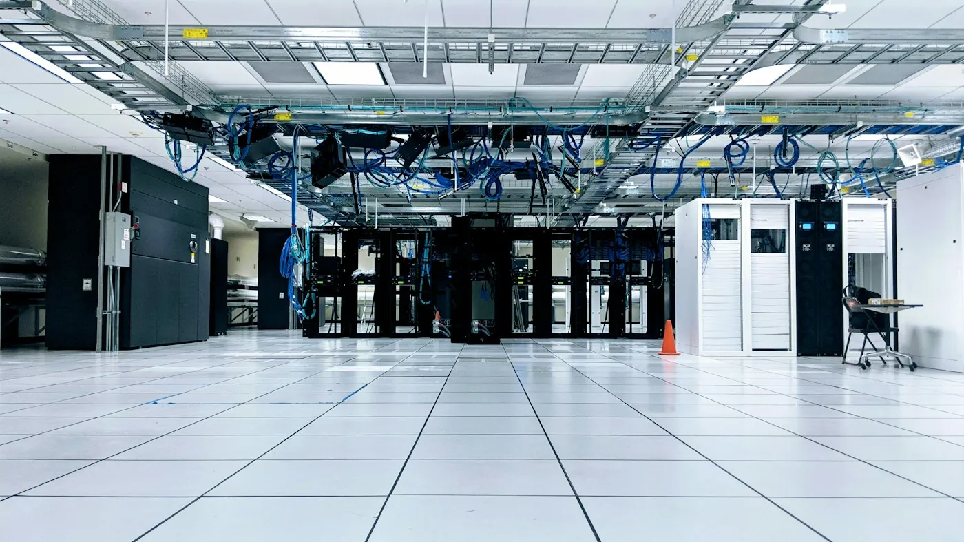 A data hall with rows of cabinets under overhead cable trays