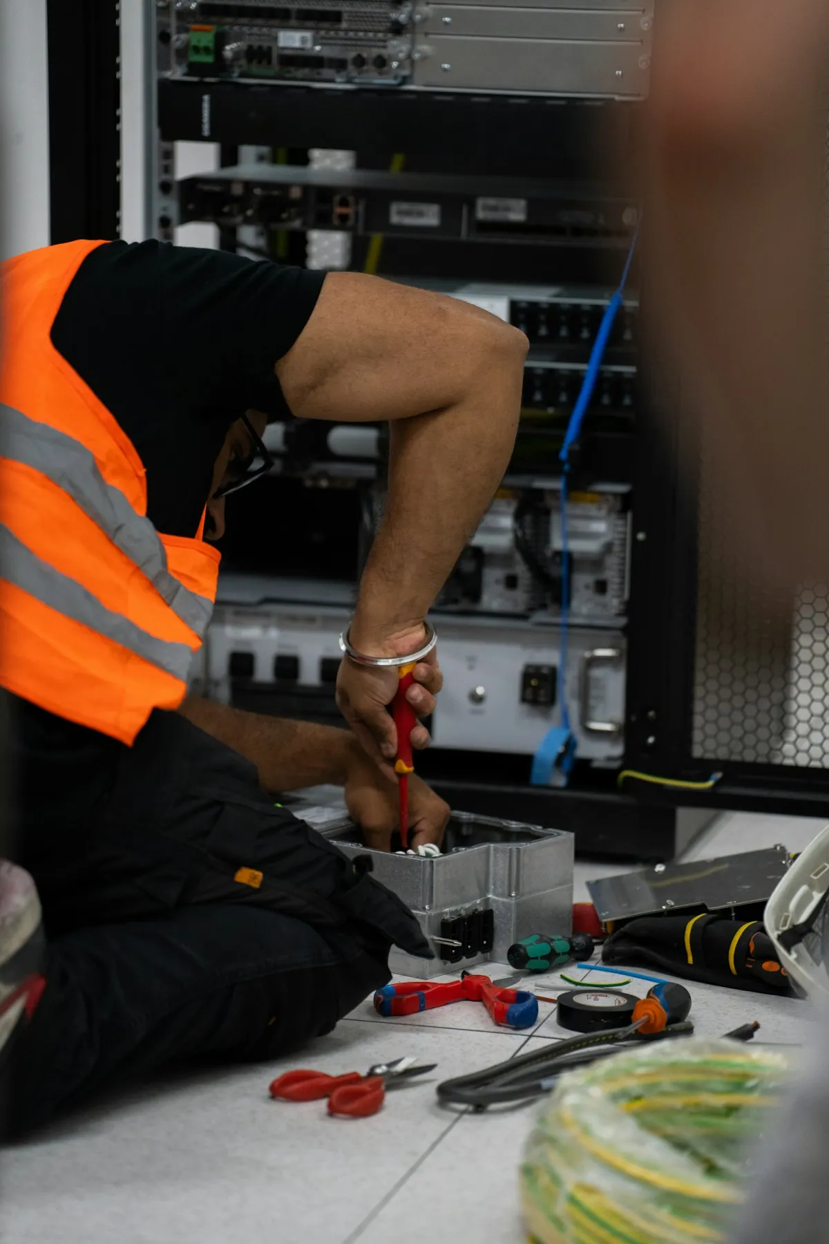 A technician working on equipment in a server rack